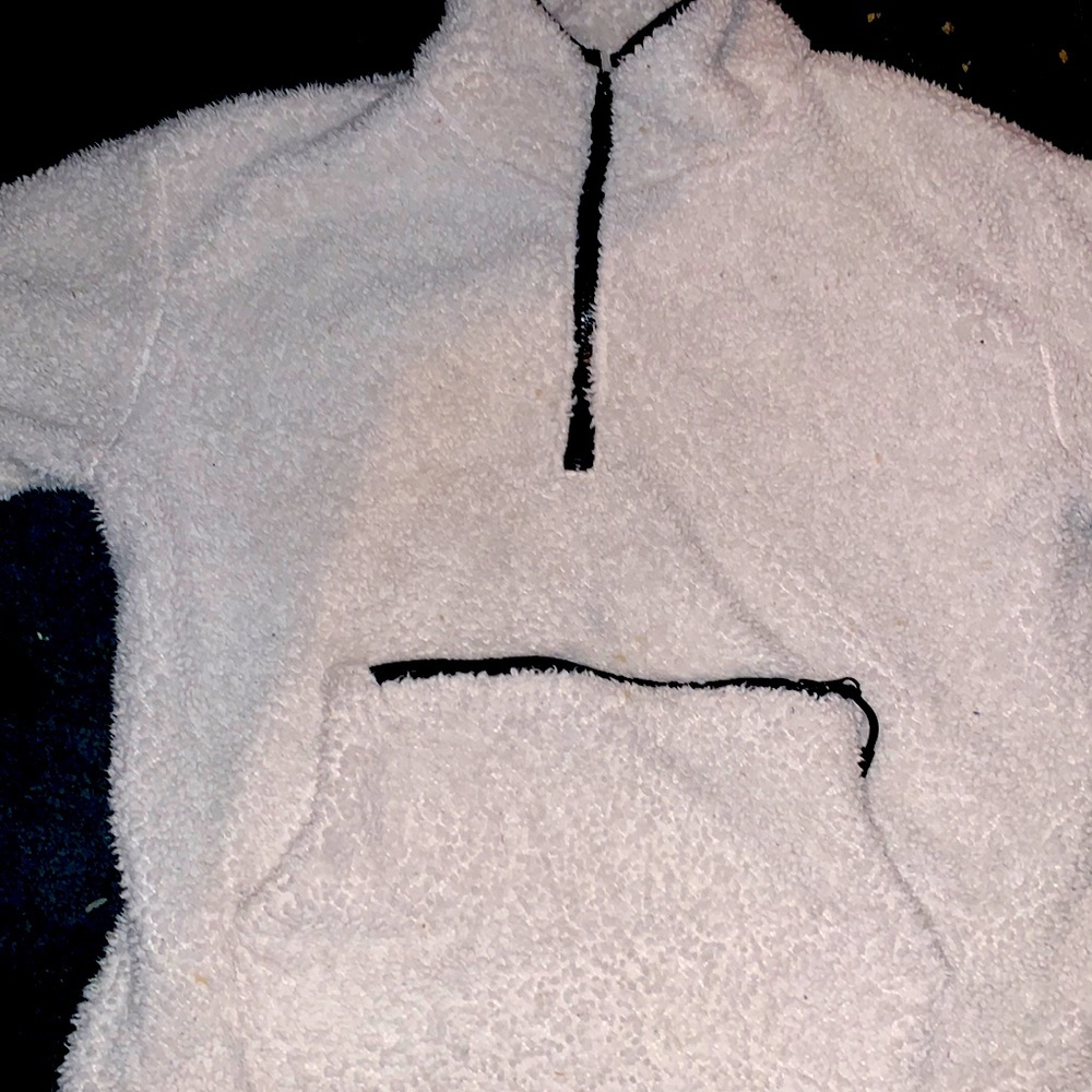 A white fluffy sweater with a tip in pocket and it’s been worn